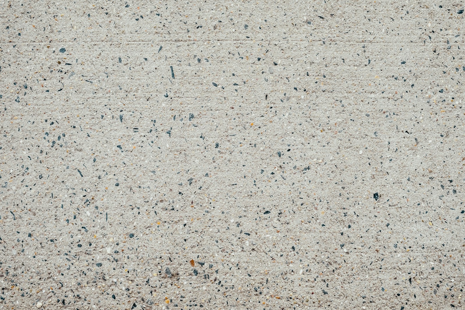 a close up of a cement surface with small black dots